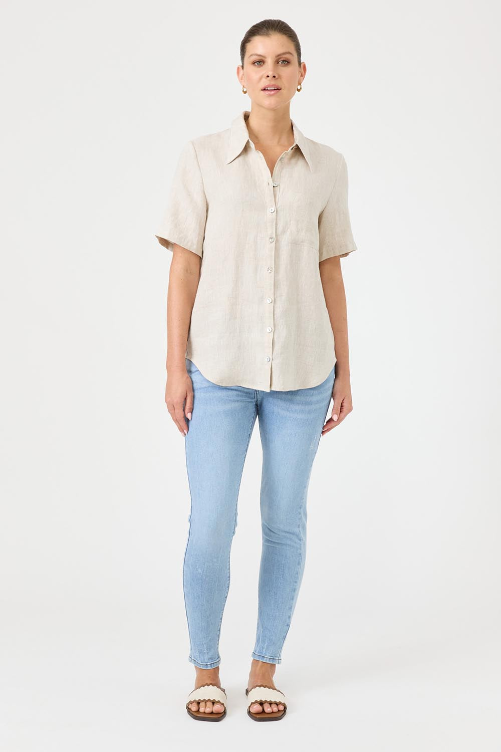 A model wearing the Studio Linen Short Sleeve Shirt in colour Dune, from the front, showing the whole outfit