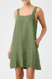 A model wearing the Studio Linen Short Tank Dress in colour Khaki (Green), from the front, cropped image