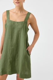 A model wearing the Studio Linen Short Tank Dress in colour Khaki (Green), from the front, cropped image