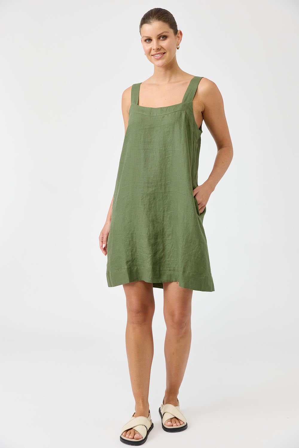 A model wearing the Studio Linen Short Tank Dress in colour Khaki (Green), from the front, showing the whole outfit