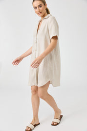 A model wearing the Studio Linen Short Shirt Dress in colour Dune, from the front, showing the whole outfit