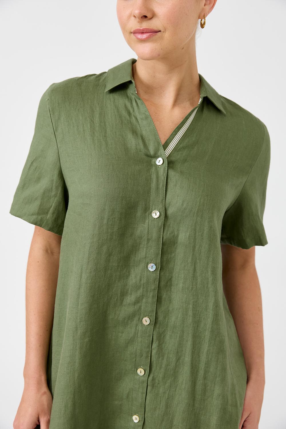 A model wearing the Studio Linen Short Shirt Dress in colour Khaki (Green), from the front, cropped image
