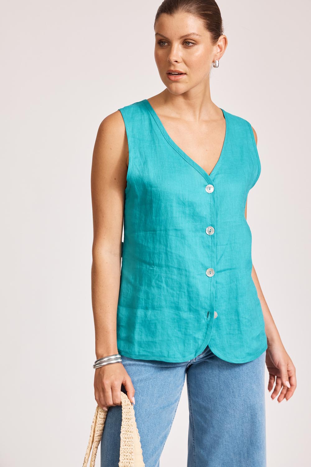 A model wearing the Miramar Linen Vest in colour Lagoon (Blue), from the front, cropped image