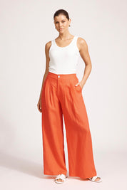 A model wearing the Miranar Linen Palazzo Pant in colour Coral (Red), from the front, showing the whole outfit