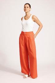 A model wearing the Miranar Linen Palazzo Pant in colour Coral (Red), from the front, showing the whole outfit