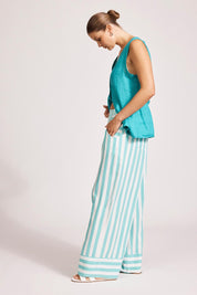 A model wearing the Treville Stripe Pant in colour Aqua (Blue), from the front, showing the whole outfit