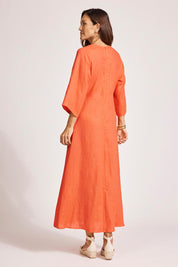 A model wearing the Miramar Twist Linen Maxi Dress in colour Coral (Red), from the back