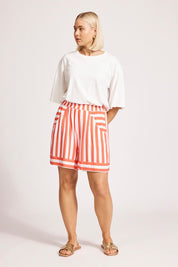 A model wearing the Treville Stripe Short in colour Coral (Red), from the front, showing the whole outfit