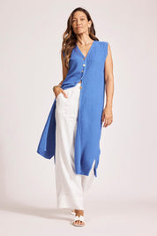 A model wearing the Artemis Cotton Knit Vest in colour Aegean (Blue), from the front, showing the whole outfit