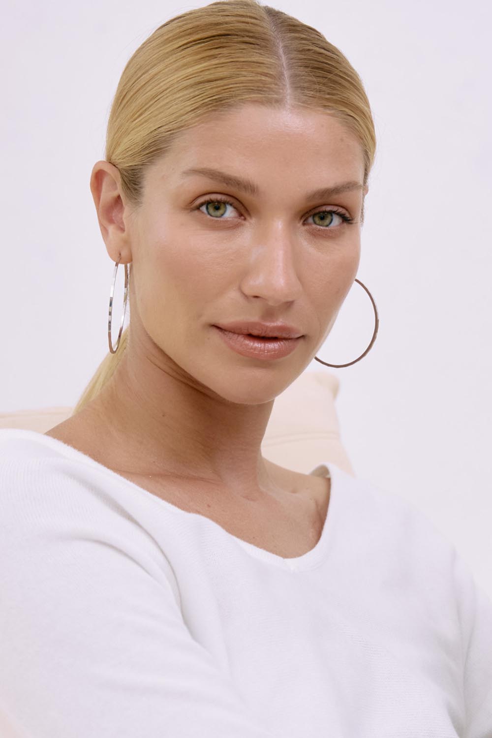 A model wearing the Pena Simple Hoop Earrings in colour Silver (Metallics), from the front, showing the whole outfit