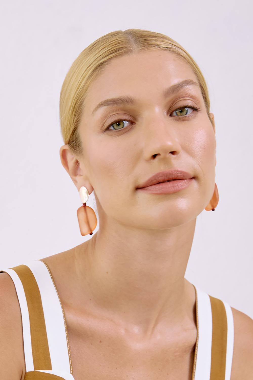A model wearing the Miramar Double Drop Earrings in colour Coral, from the front, showing the whole outfit