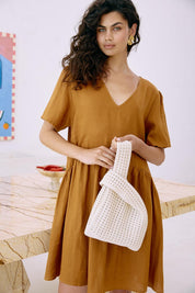 A model wearing the Positano Tote in colour Clay, from the front, showing the whole outfit