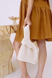 A model wearing the Positano Tote in colour Clay, from the front, showing the whole outfit