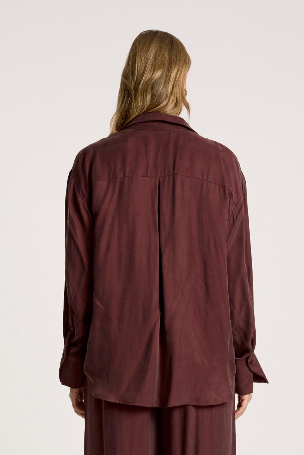 A model wearing the Calista Shirt in colour Mahogany (Red), from the back