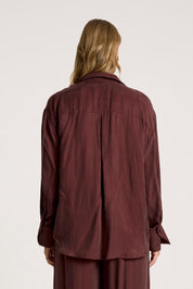 A model wearing the Calista Shirt in colour Mahogany (Red), from the back