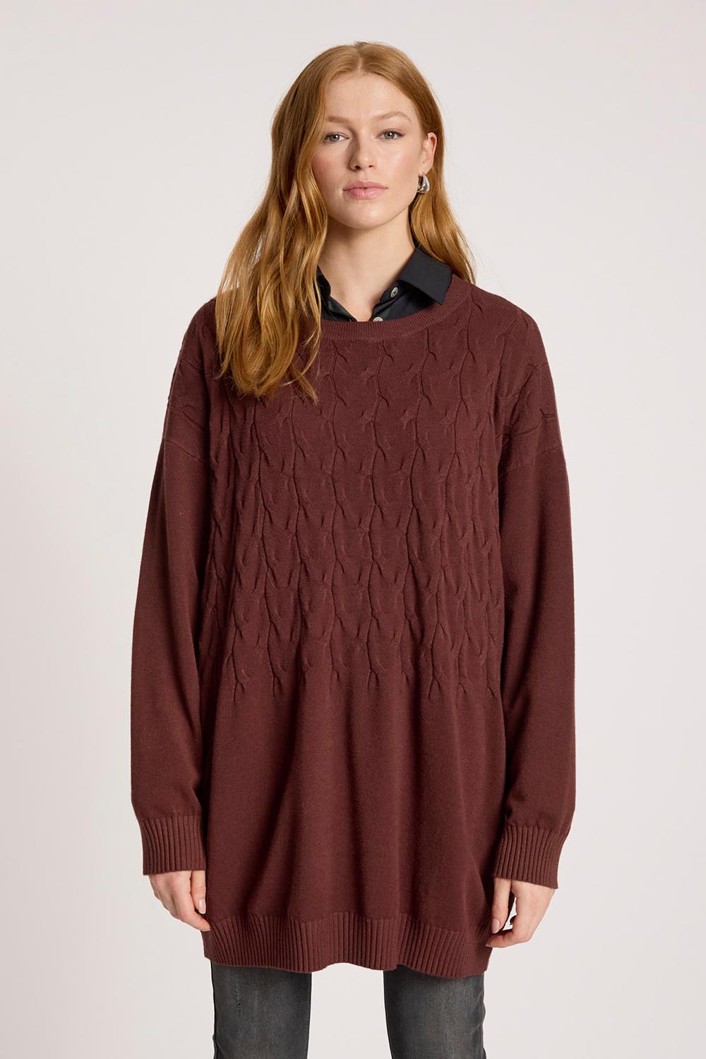A model wearing the Samira Relaxed Knit in colour Mahogany (Red), from the front, cropped image