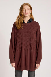 A model wearing the Samira Relaxed Knit in colour Mahogany (Red), from the front, cropped image