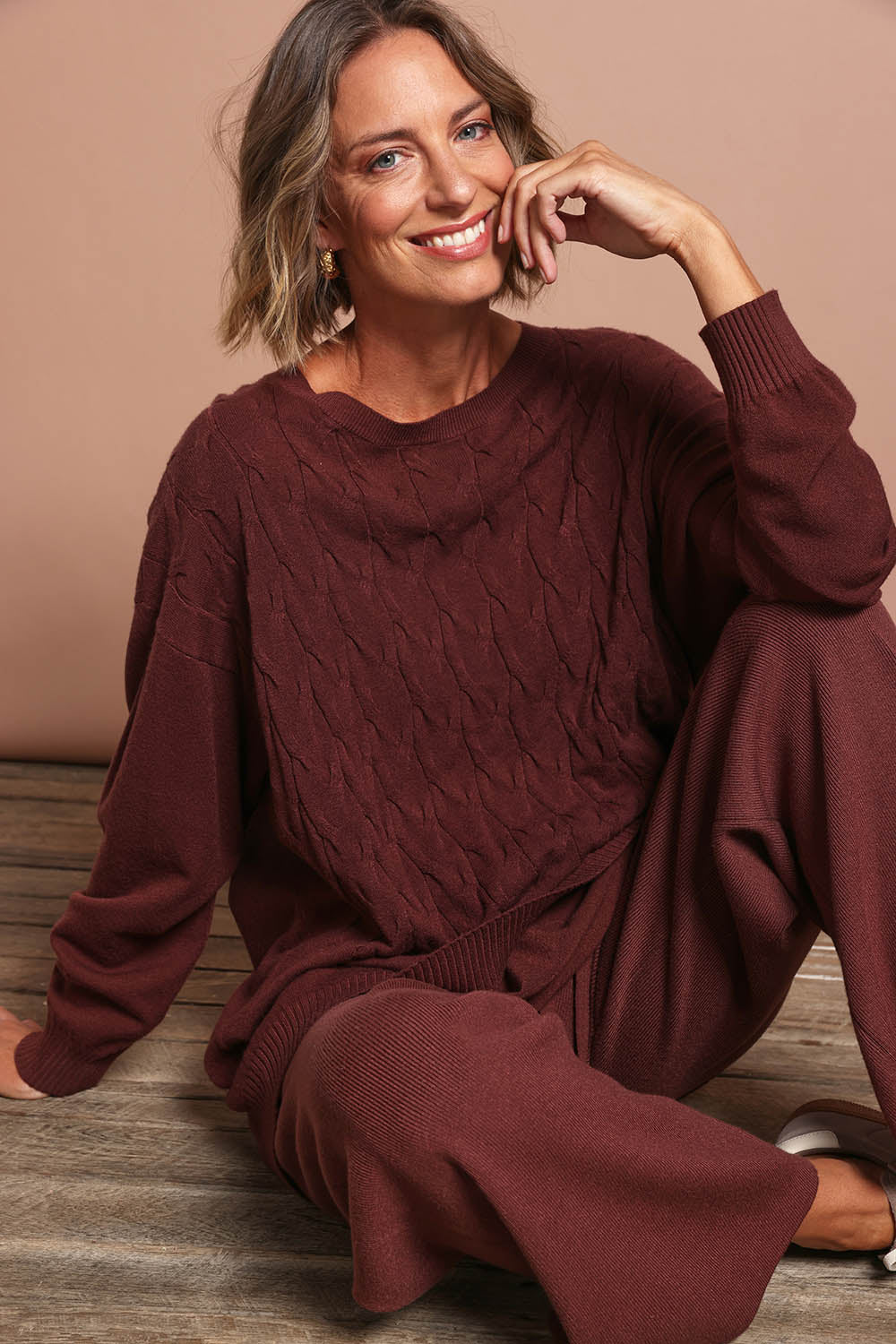 Model Riina wearing the Samira Relaxed Knit in colour Mahogany (Red), from the front, showing the whole outfit