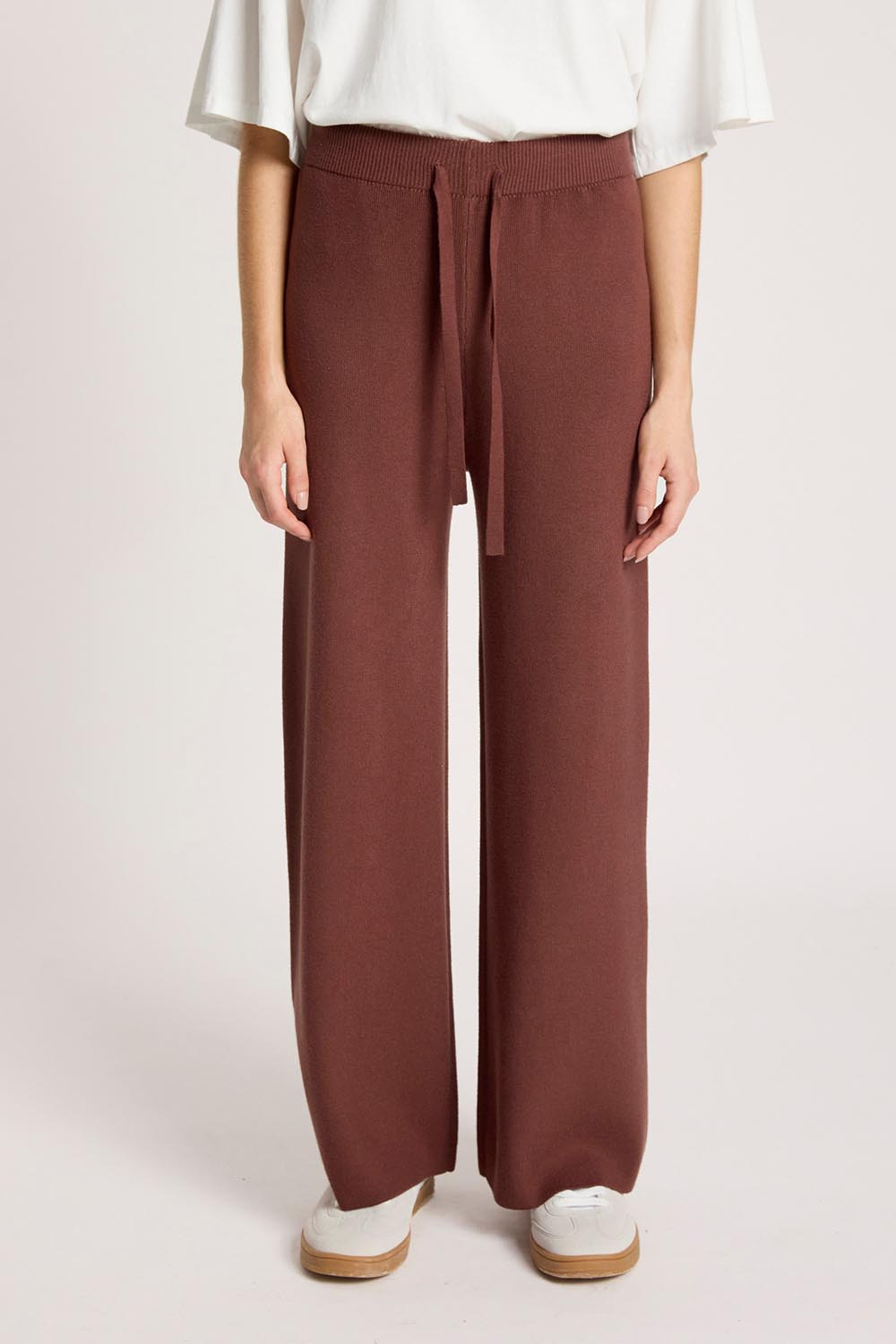 Model Genericm wearing size sample of the Samira Knit Pant - Mahogany in colour Mahogany, in a cropped view