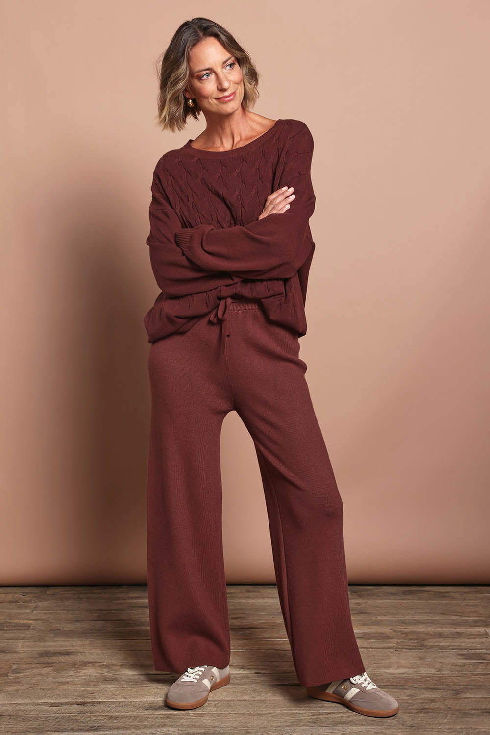 Model Riina wearing the Samira Knit Pant in colour Mahogany (Red), from the front, showing the whole outfit