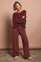 Model Riina wearing the Samira Knit Pant in colour Mahogany (Red), from the front, showing the whole outfit