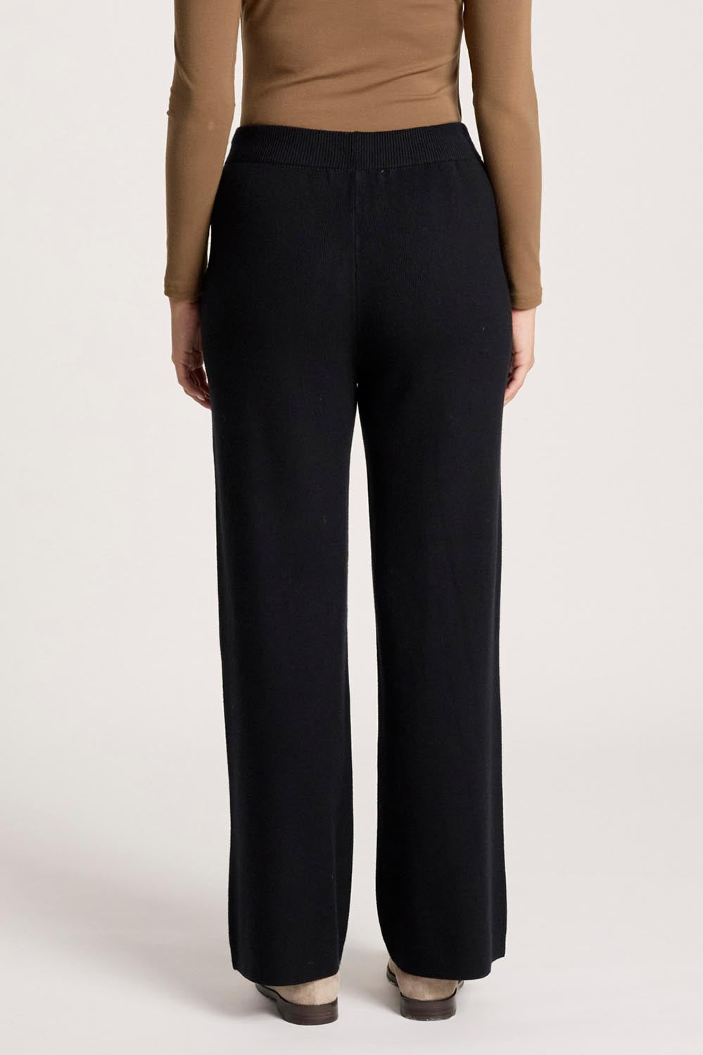 A model wearing the Samira Knit Pant in colour Black (Black), from the back