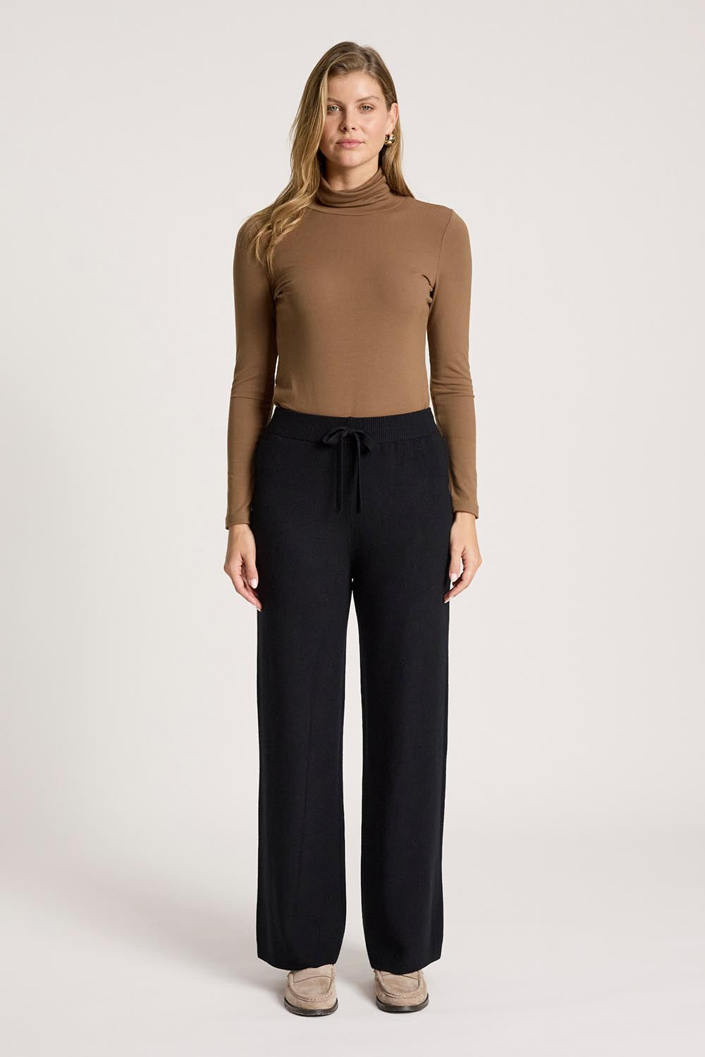 A model wearing the Samira Knit Pant in colour Black (Black), from the front, showing the whole outfit