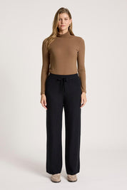 A model wearing the Samira Knit Pant in colour Black (Black), from the front, showing the whole outfit