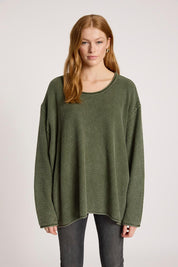 A model wearing the Apache Jumper in colour Pampas (Green), from the front, cropped image