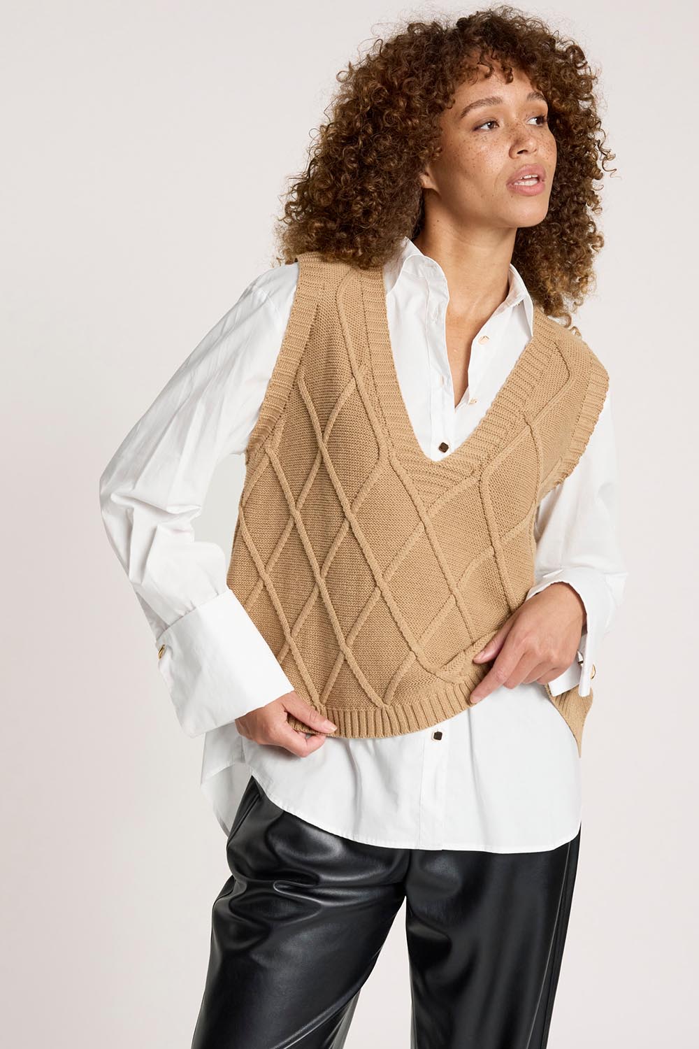 A model wearing the Liora Knit Vest in colour Mocha, from the front, cropped image