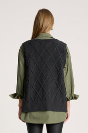 A model wearing the Liora Knit Vest in colour Char (Black), from the back
