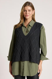 A model wearing the Liora Knit Vest in colour Char (Black), from the front, cropped image