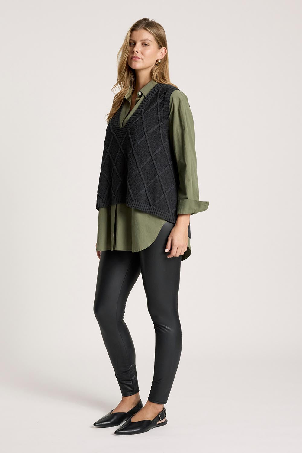 A model wearing the Liora Knit Vest in colour Char (Black), from the front, showing the whole outfit