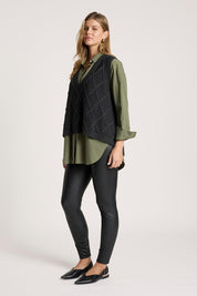 A model wearing the Liora Knit Vest in colour Char (Black), from the front, showing the whole outfit