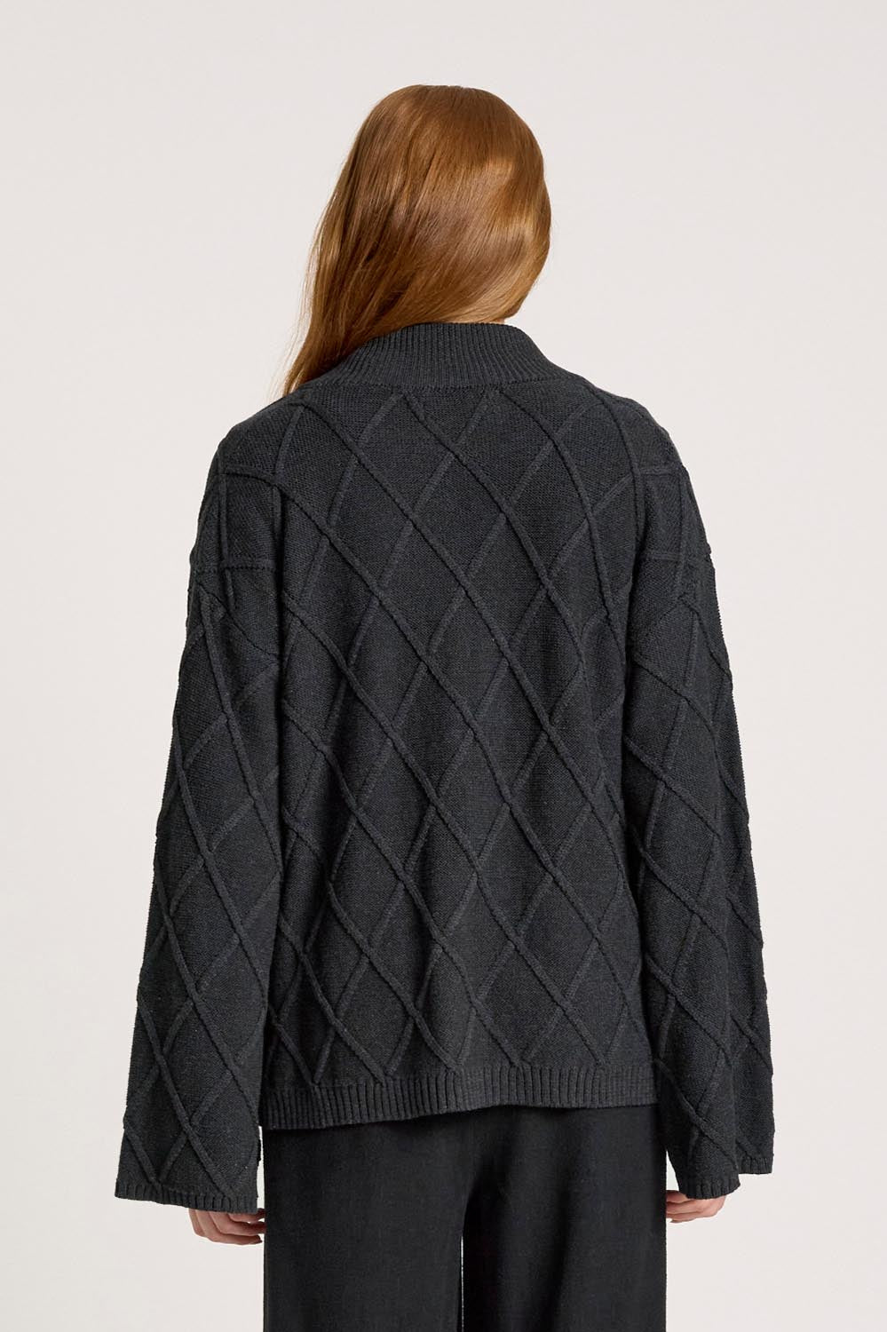 A model wearing the Liora Crop Cardigan in colour Charcoal (Black), from the front, cropped image