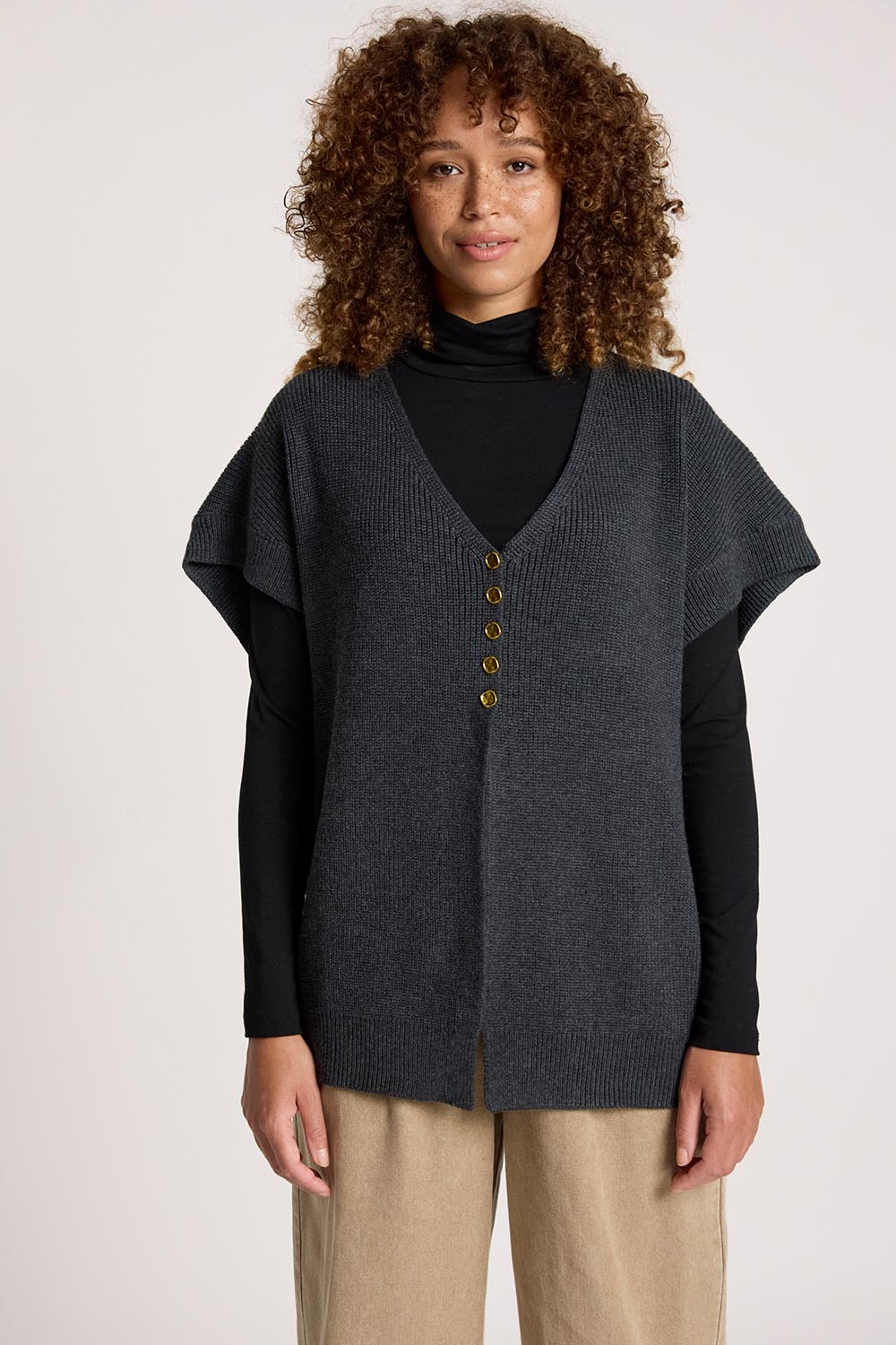 A model wearing the Berber Vest Cardigan in colour Charcoal (Black), from the front, cropped image
