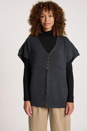A model wearing the Berber Vest Cardigan in colour Charcoal (Black), from the front, cropped image