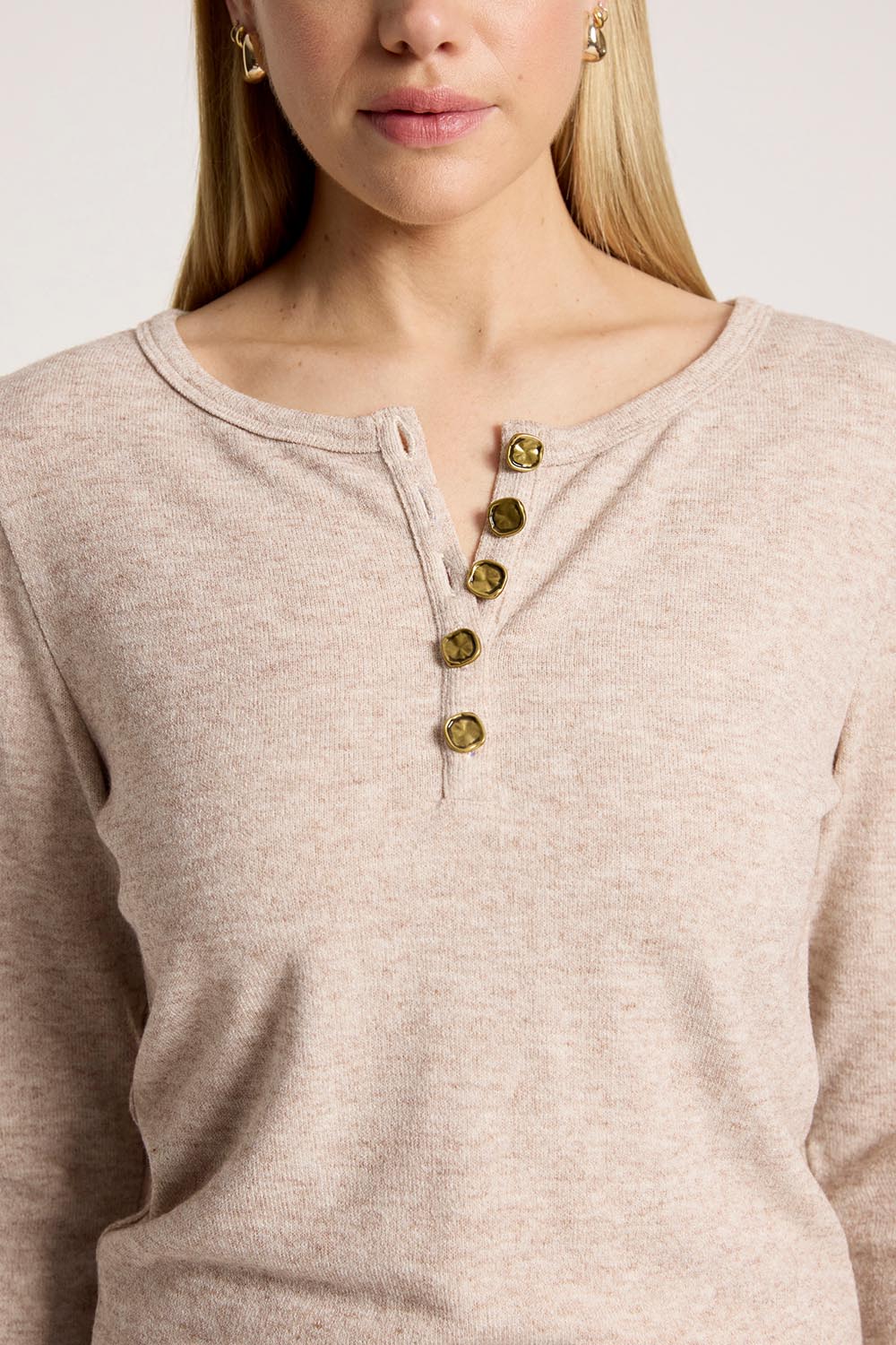 A model wearing the Rumi Long Sleeve Top in colour Bisque, from the front, cropped image