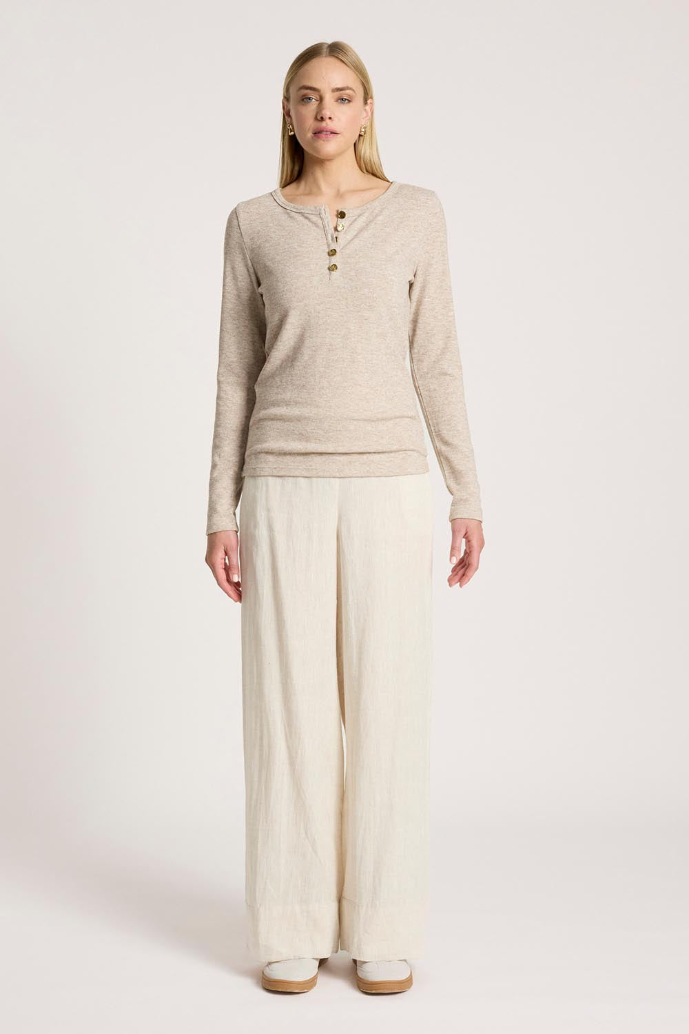 A model wearing the Rumi Long Sleeve Top in colour Bisque, from the front, showing the whole outfit