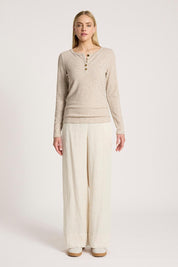 A model wearing the Rumi Long Sleeve Top in colour Bisque, from the front, showing the whole outfit