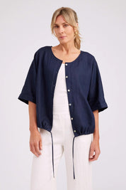 Model Genericm wearing size sample of the Studio Linen Button Top Jacket – Navy in colour Navy, in a cropped view