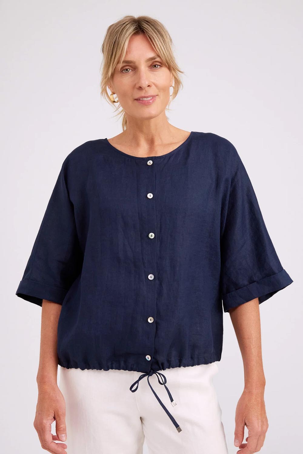 Model Genericm wearing size sample of the Studio Linen Button Top Jacket – Navy in colour Navy, in a cropped view