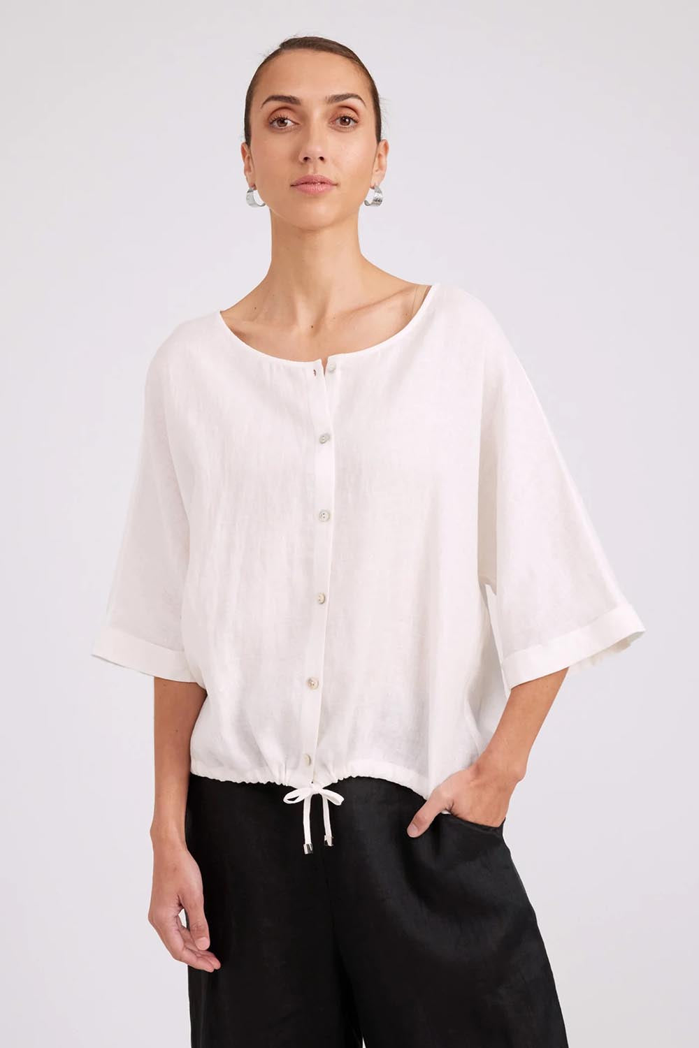 Model Genericm wearing size sample of the Studio Linen Button Top Jacket – White in colour White, in a cropped view