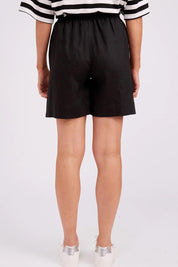 Model Genericm wearing size sample of the Studio Linen Bermuda Short – Black in colour Black, from the back