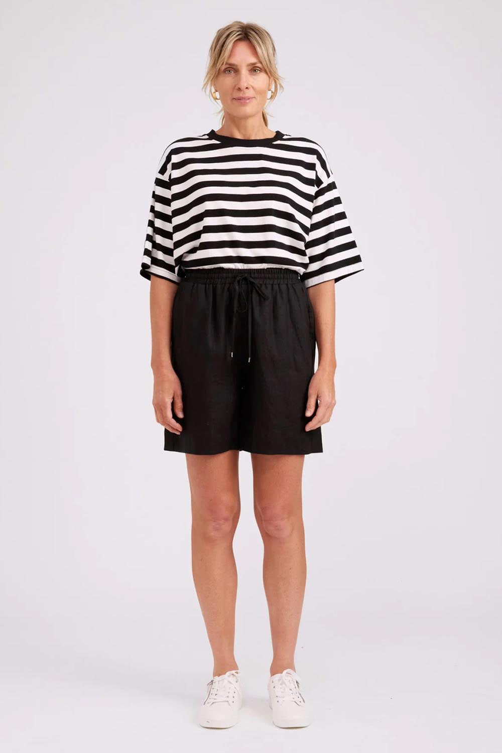 Model Genericm wearing size sample of the Studio Linen Bermuda Short – Black in colour Black, from the front