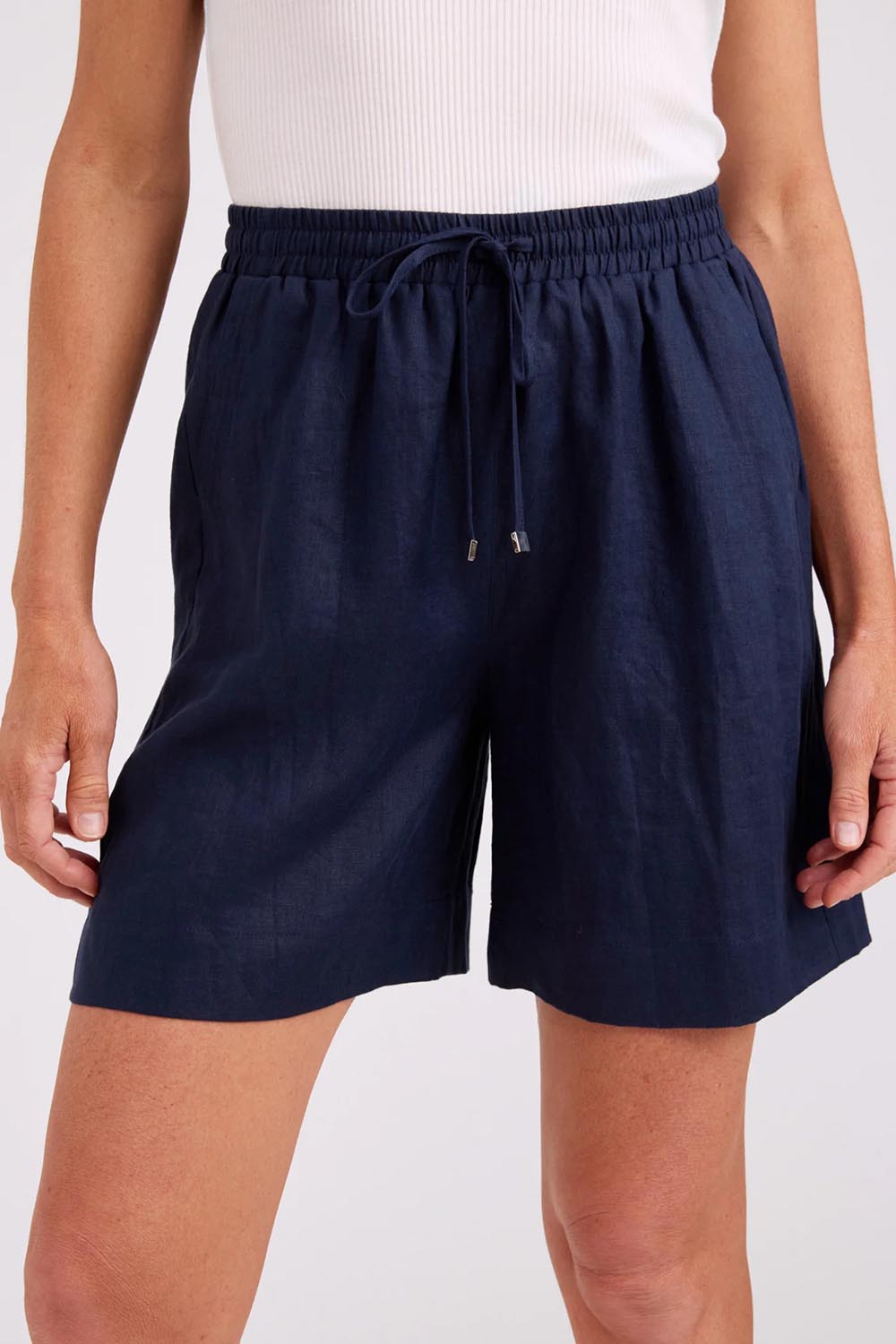 Model Genericm wearing size sample of the Studio Linen Bermuda Short – Navy in colour Navy, in a cropped view