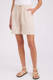 Model Genericm wearing size sample of the Studio Linen Bermuda Short – Tusk in colour Tusk, in a cropped view