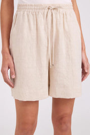 Model Genericm wearing size sample of the Studio Linen Bermuda Short – Tusk in colour Tusk, in a cropped view