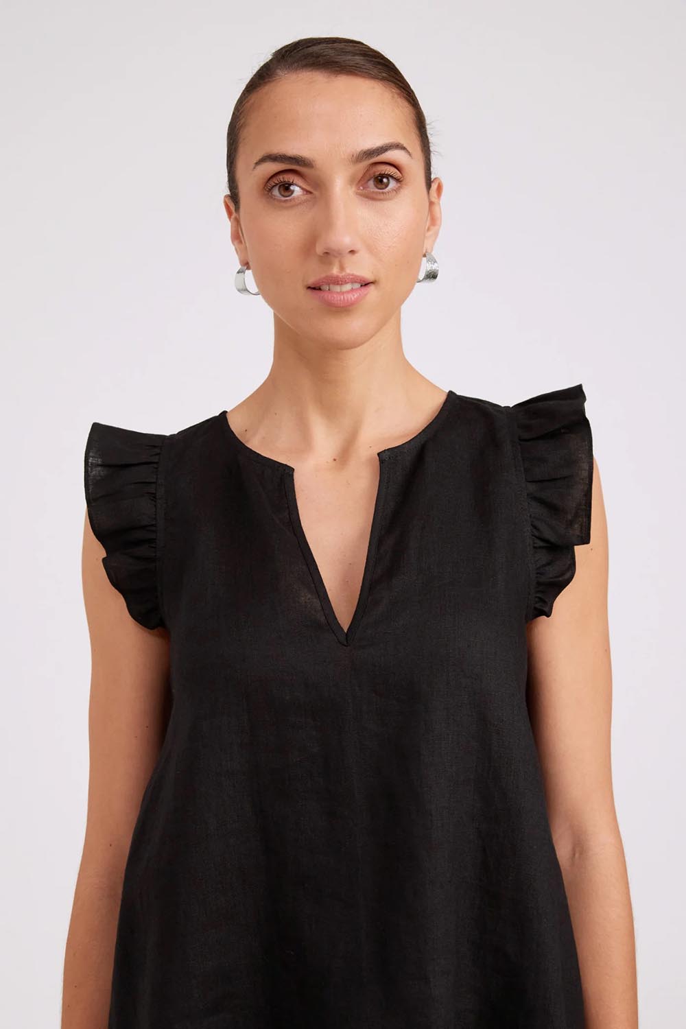 Model Genericm wearing size sample of the Studio Linen Frill Tank – Black in colour Black, in a cropped view