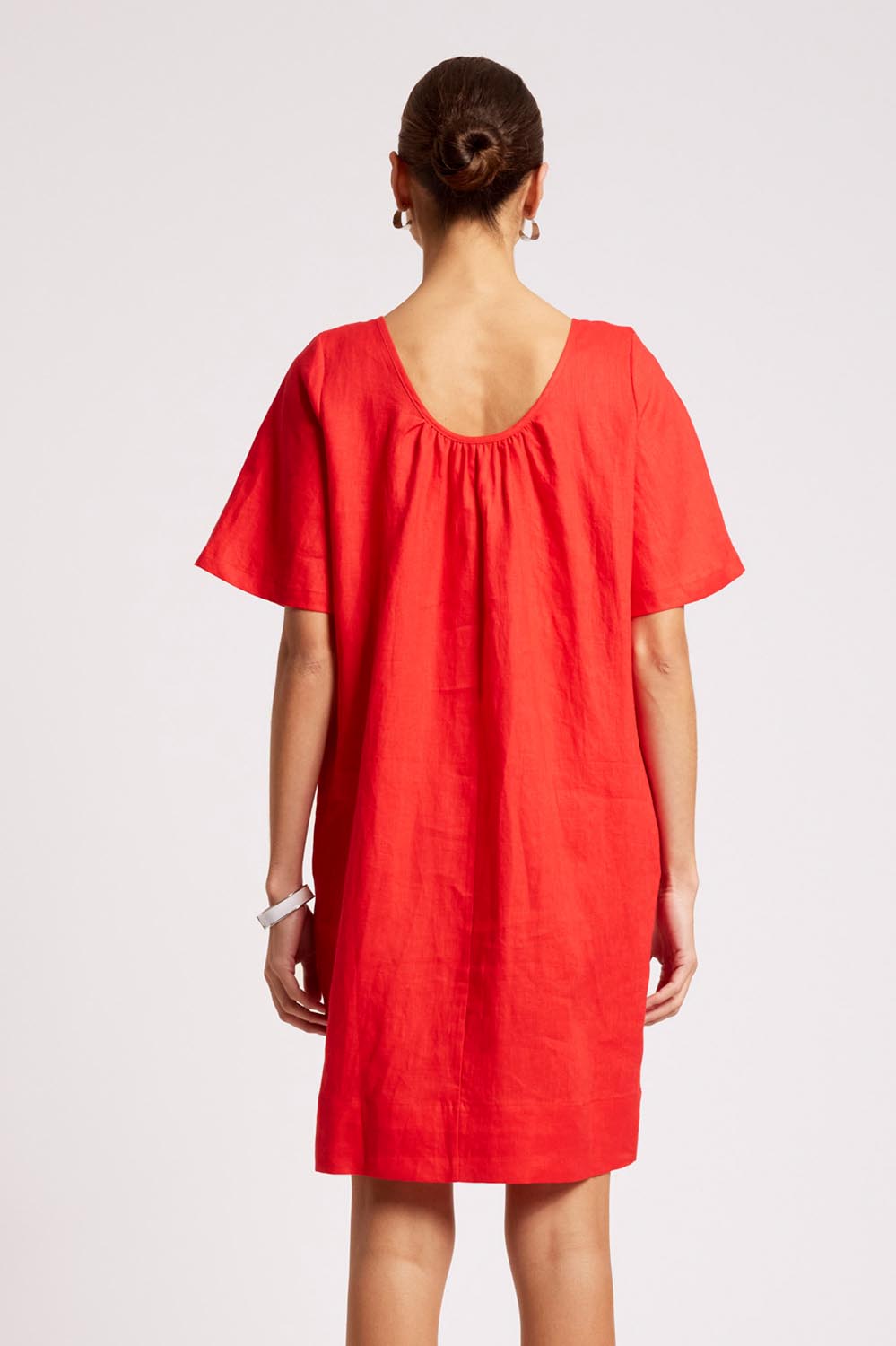 Model Genericm wearing size sample of the Cove Dress – Aperol in colour Aperol, from the back